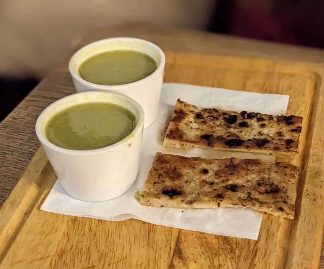 A small starter of pea and coriander soup with crispy naan bread