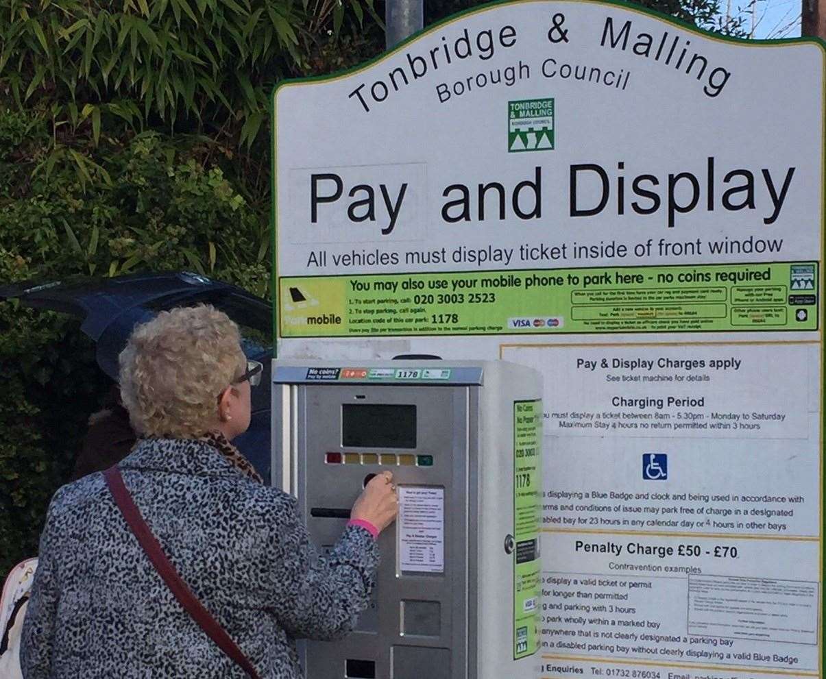 A woman using the pay machine in West Mallling High Street car park