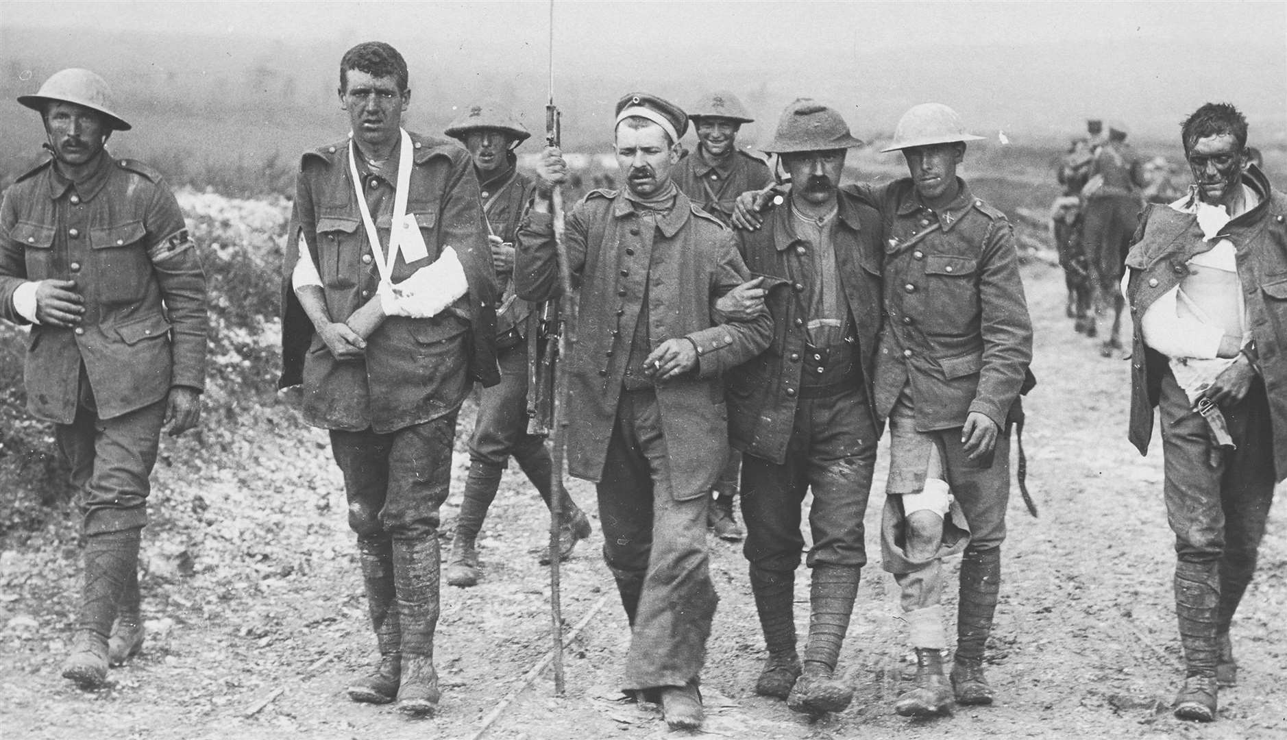 A wounded German prisoner of war assisting wounded British soldiers on the Somme front. Picture credit: National Army Museum/Press Association Images