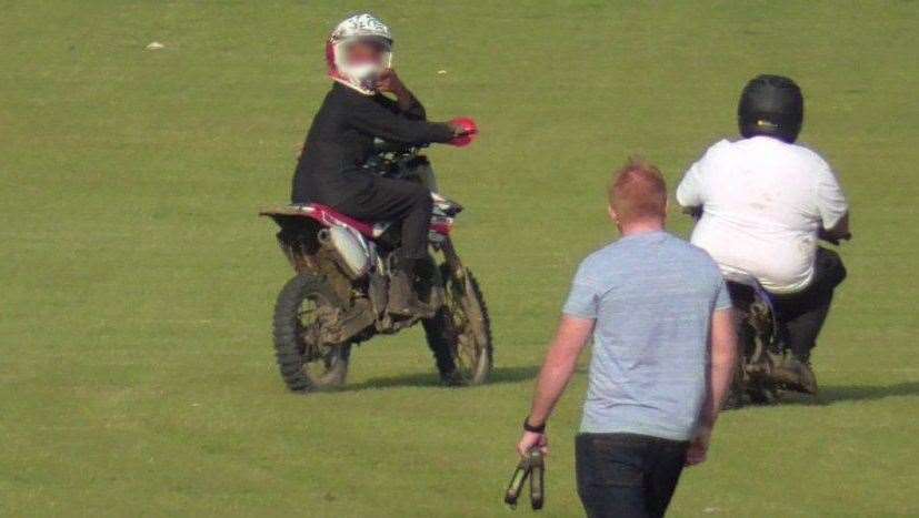 A biker gestures at a dog walker after riding past them at Barnfield Recreation Ground on September 3