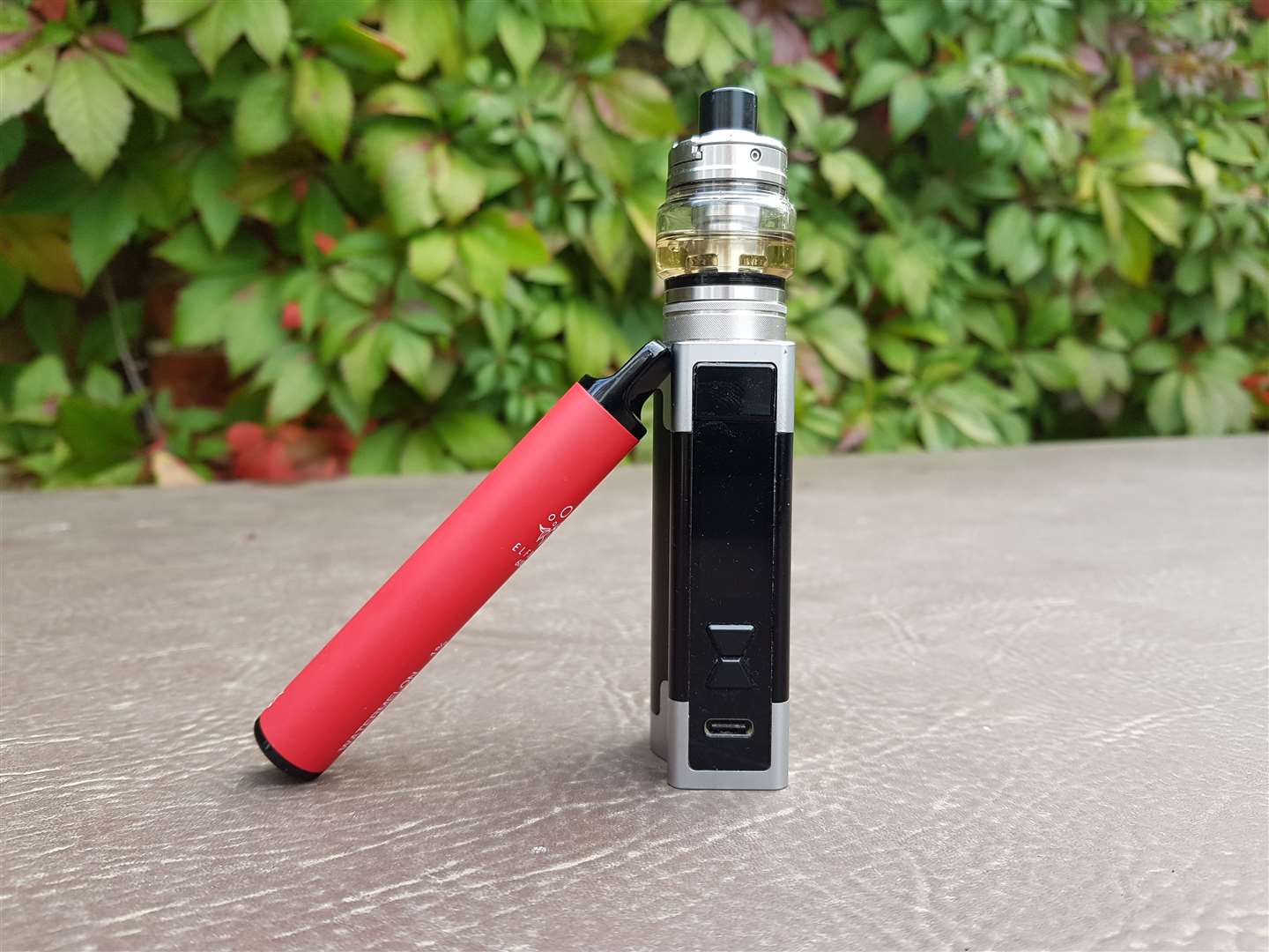 The traditional tank vape device - with the new breed of disposable leaning against it