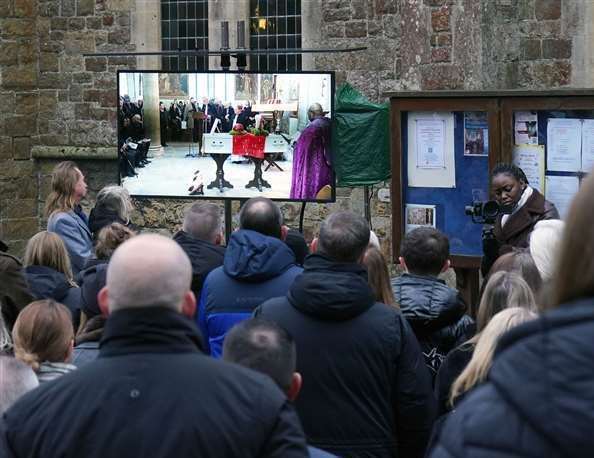 Mourners watching the funeral of William Brown on a screen outside at St Mary And St Eanswythe Church, Folkestone. Picture: Gareth Fuller/PA