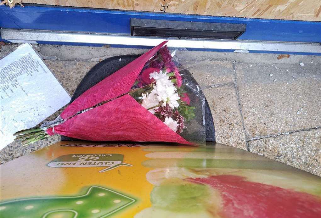 Flowers were placed behind a sign at the entrance to Thenu Convenience Store in Snargate Street, Dover after the attack