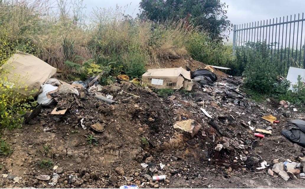 There are piles of dirt on the roadside