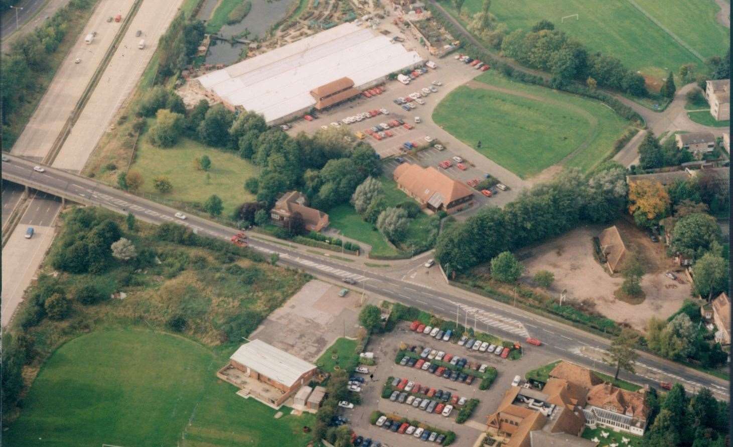 An aerial view of the site taken in 1990 shows the junction of Cemetery Lane and Canterbury Road with the Longacres garden centre at the back. The old barn on the right became Harvester in 1997. Picture: Steve Salter