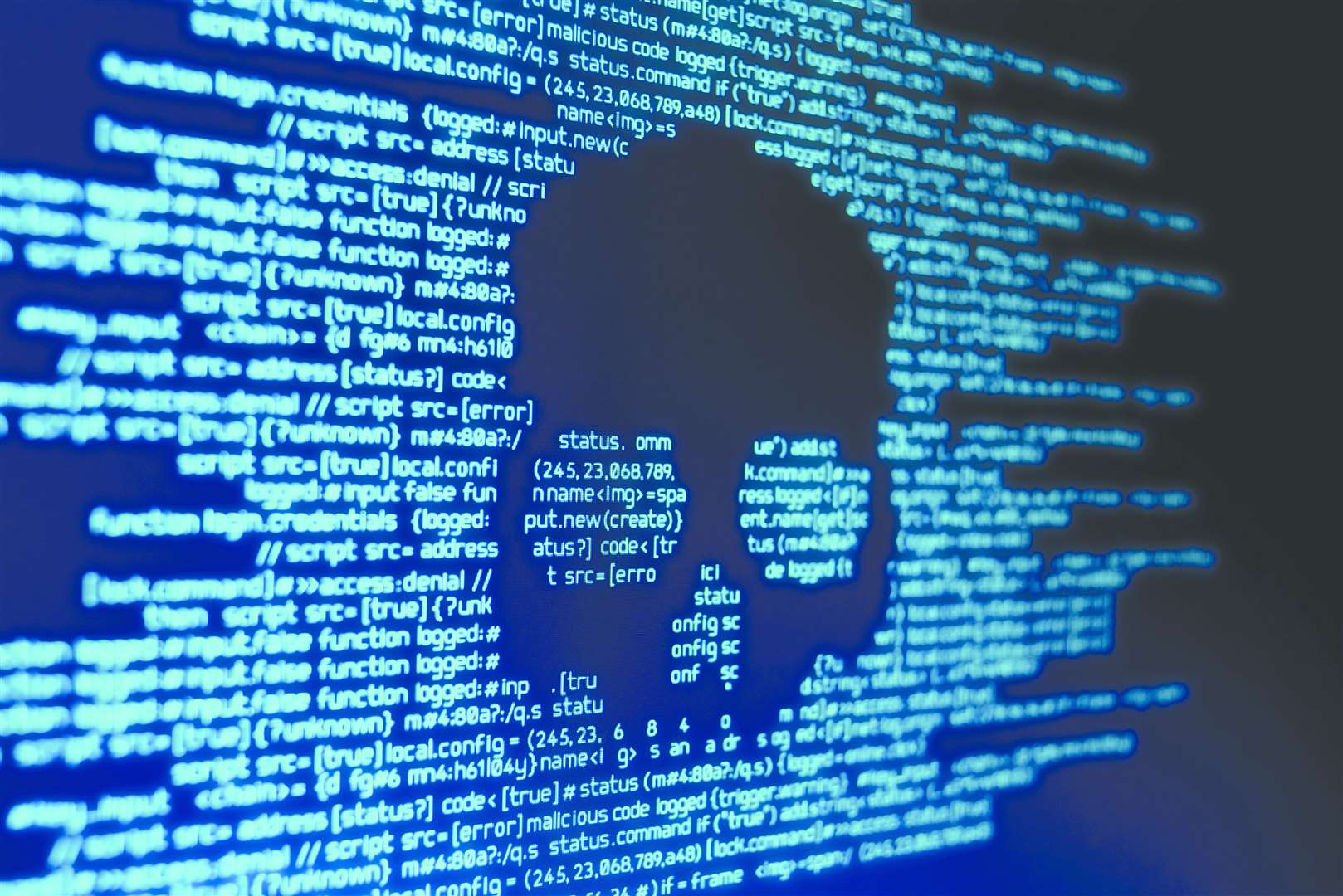 Computer code on a screen with a skull representing a computer virus attack
