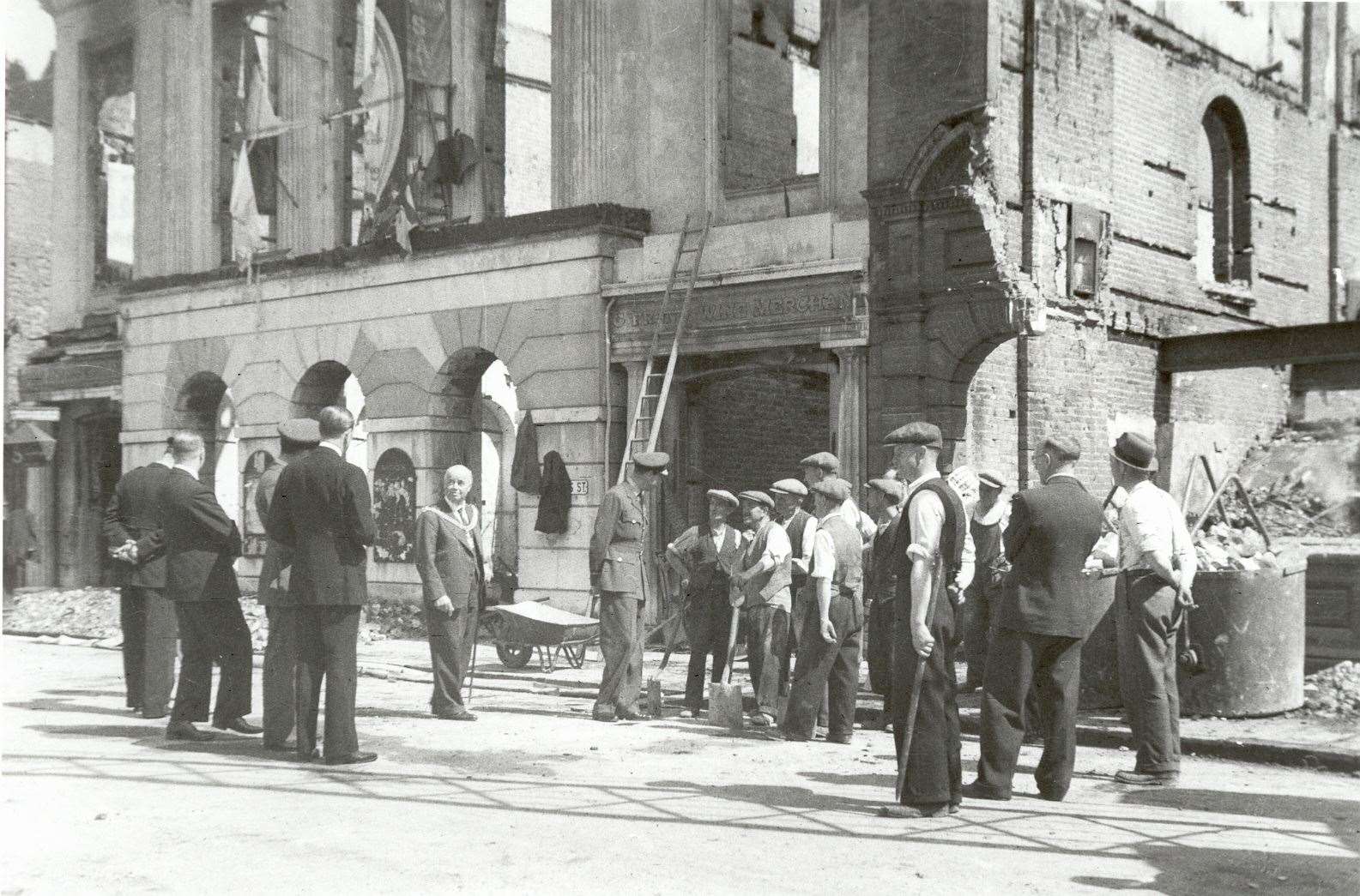 The Duke of Kent chats to demolition workers in front of the remains of the Corn Exchange facade