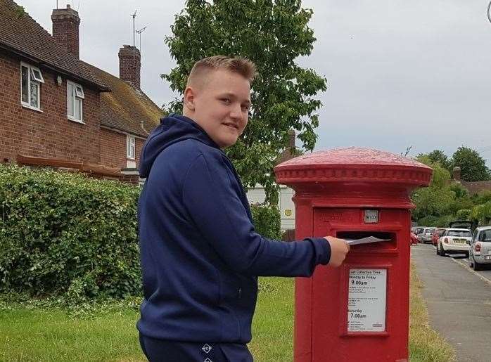 A student from The Hayesbrook School, Louis in Year 7, posting a letter to residents at Tonbridge House Care Home