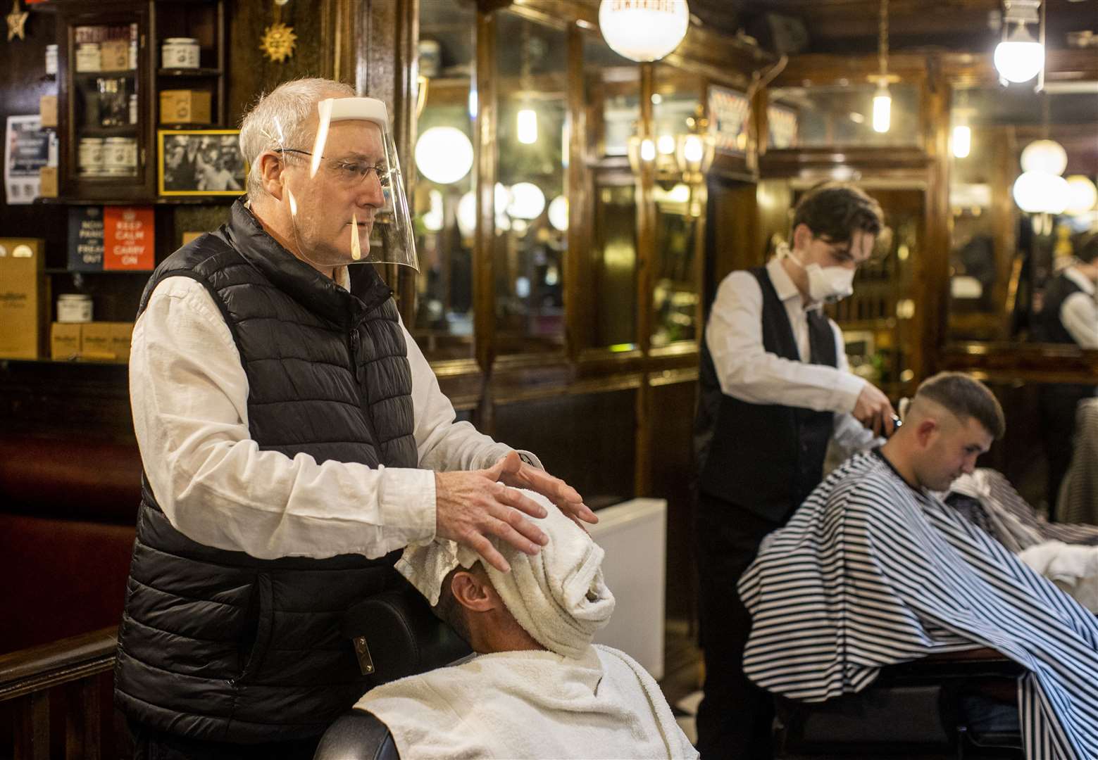 Staff at Cambridge Barbershop on the Lisburn Road were wearing personal protective equipment and visors while chairs were separated to just below two metres apart (Liam McBurney/PA)