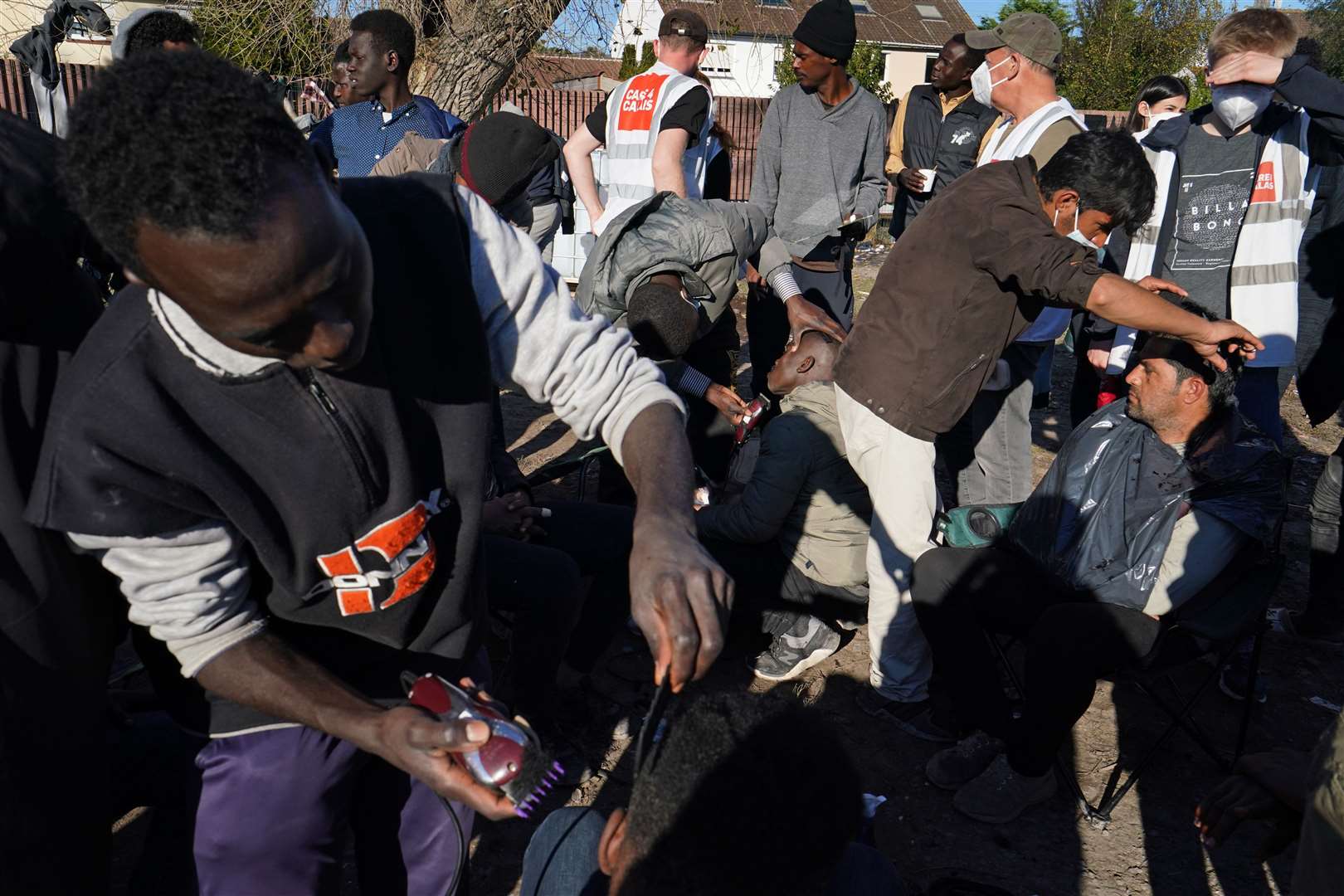 Men cut each other’s hair at the camp (Gareth Fuller/PA)