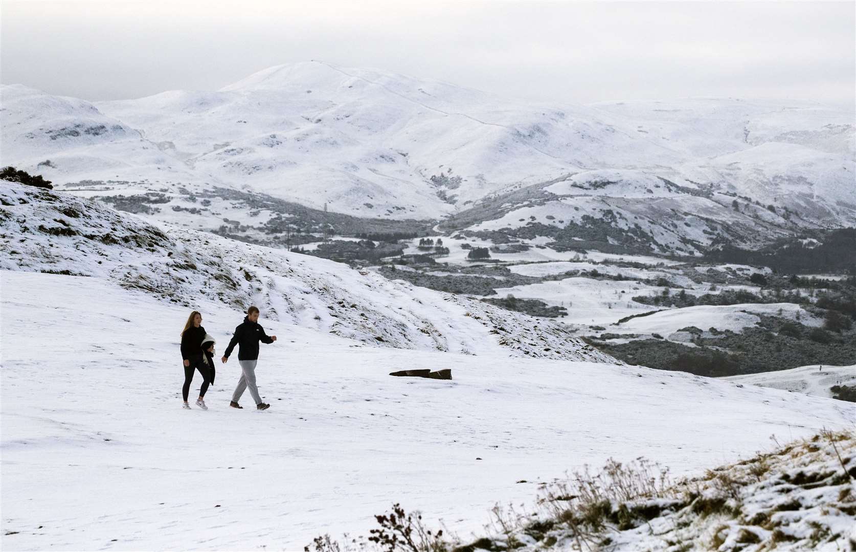 It was almost a scene from a Christmas card as a couple walked through Holyrood Park in Edinburgh (Jane Barlow/PA)