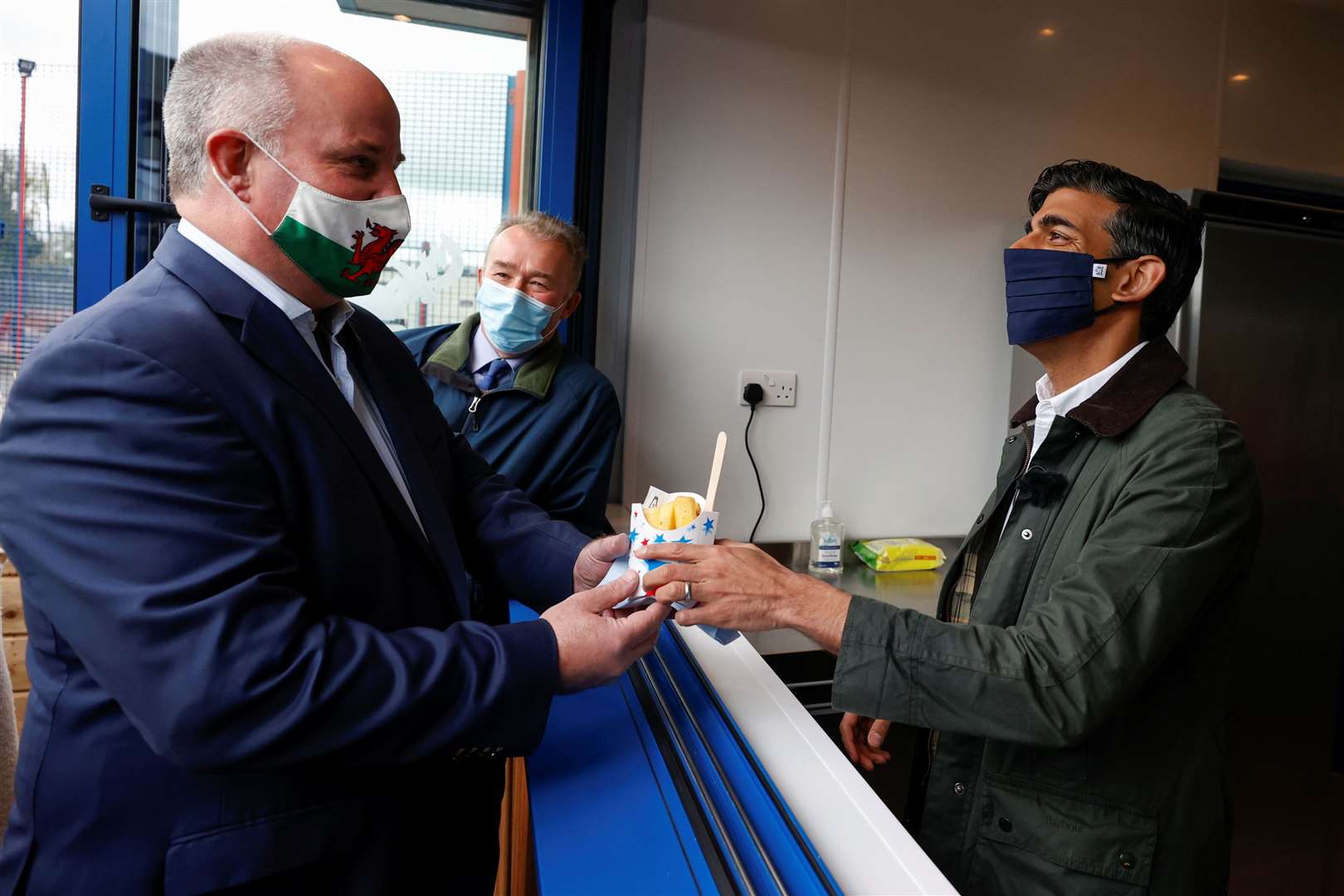 Rishi Sunak serves chips to Andrew RT Davies (left), with Simon Hart during a visit to the Marine Holiday Park in Rhyl (Phil Noble/PA)