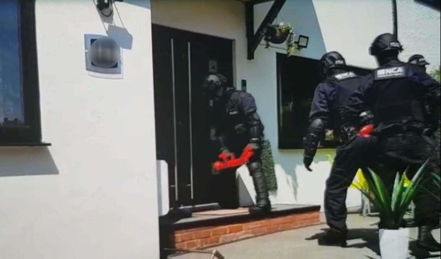 National Crime Agency officers conducting a raid on a property in Croydon (National Crime Agency/PA)