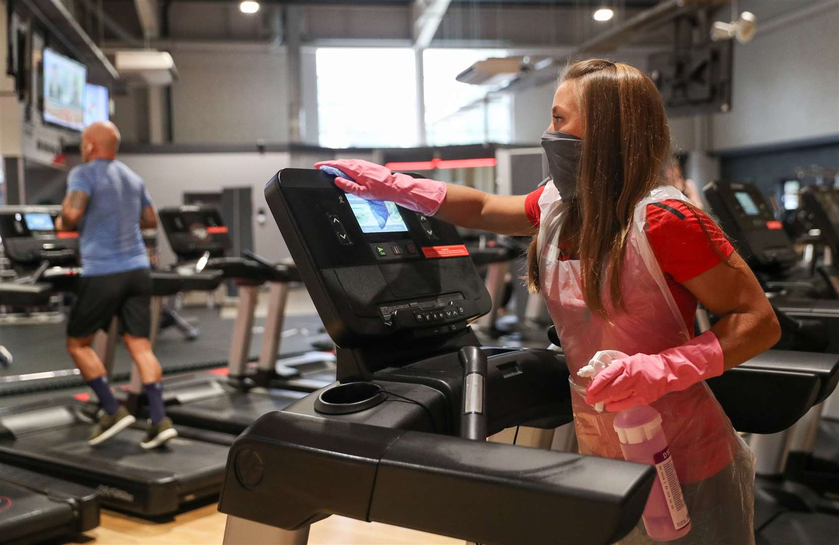 General manager Tori Waight cleans a treadmill at DW Fitness First in Basingstoke (Andrew Matthews/PA)