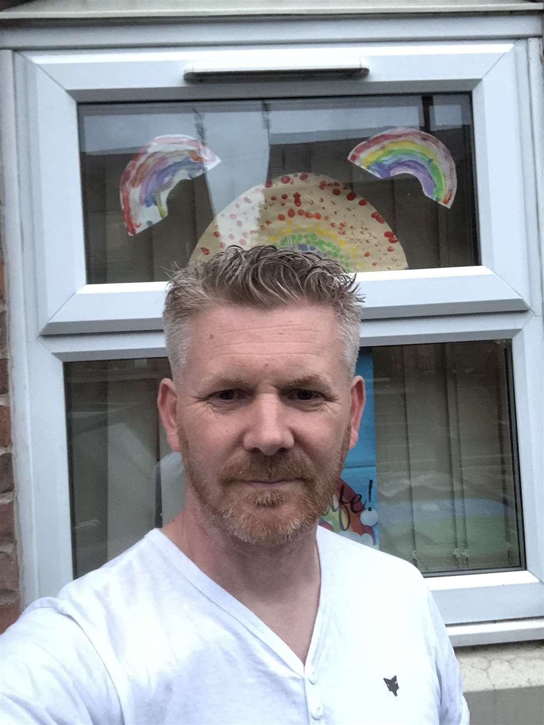 James Jackson, in front of rainbows his children have drawn to thank NHS workers (James Jackson)