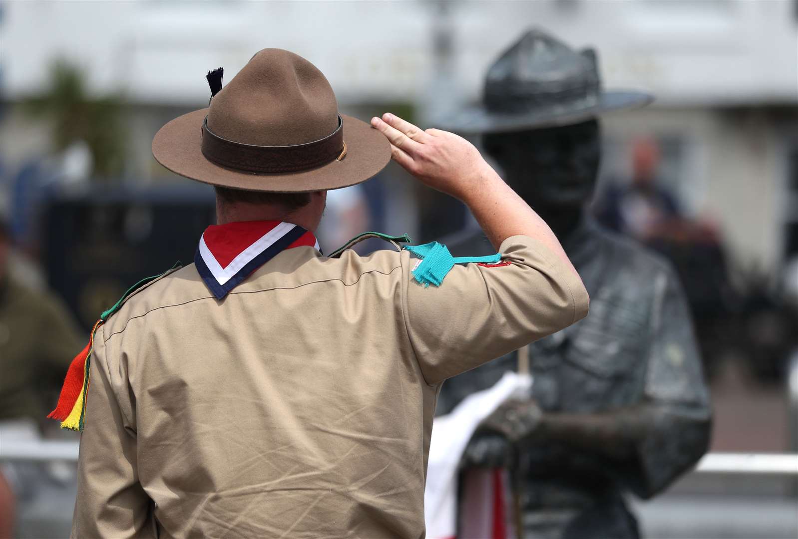 Rover Scout Matthew Trott salutes a statue of Robert Baden-Powell on Poole Quay in Dorset (Andrew Matthews/PA)