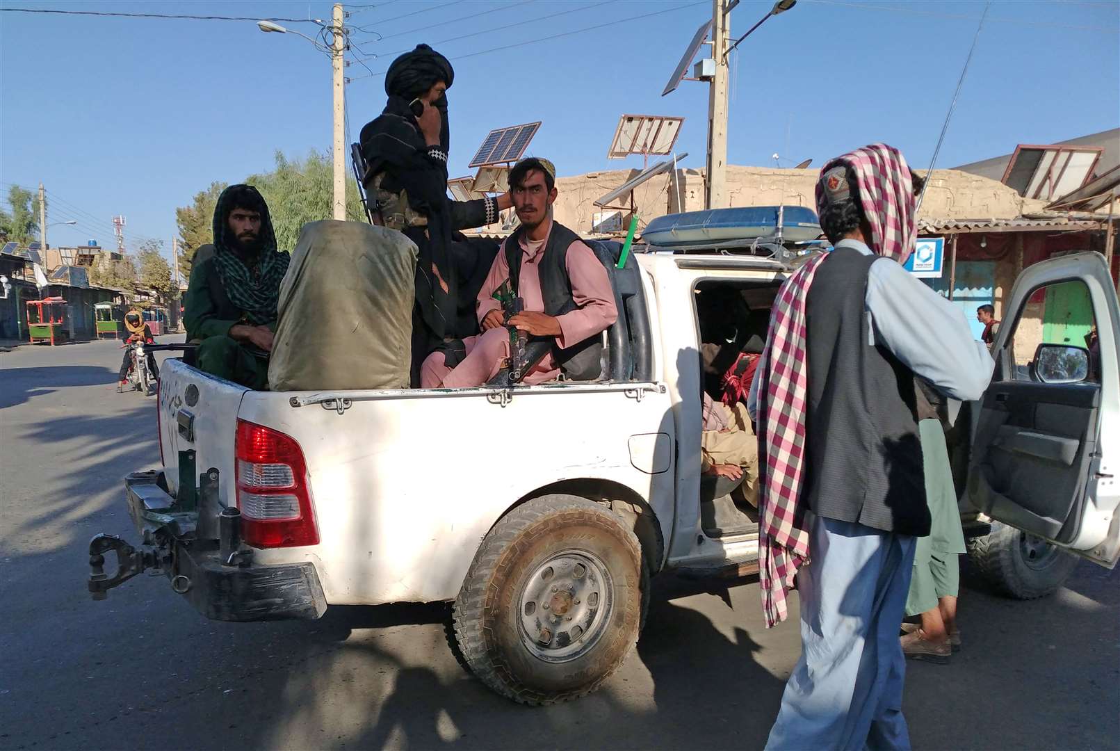 Taliban fighters patrol inside the city of Farah (Mohammad Asif Khan/AP)