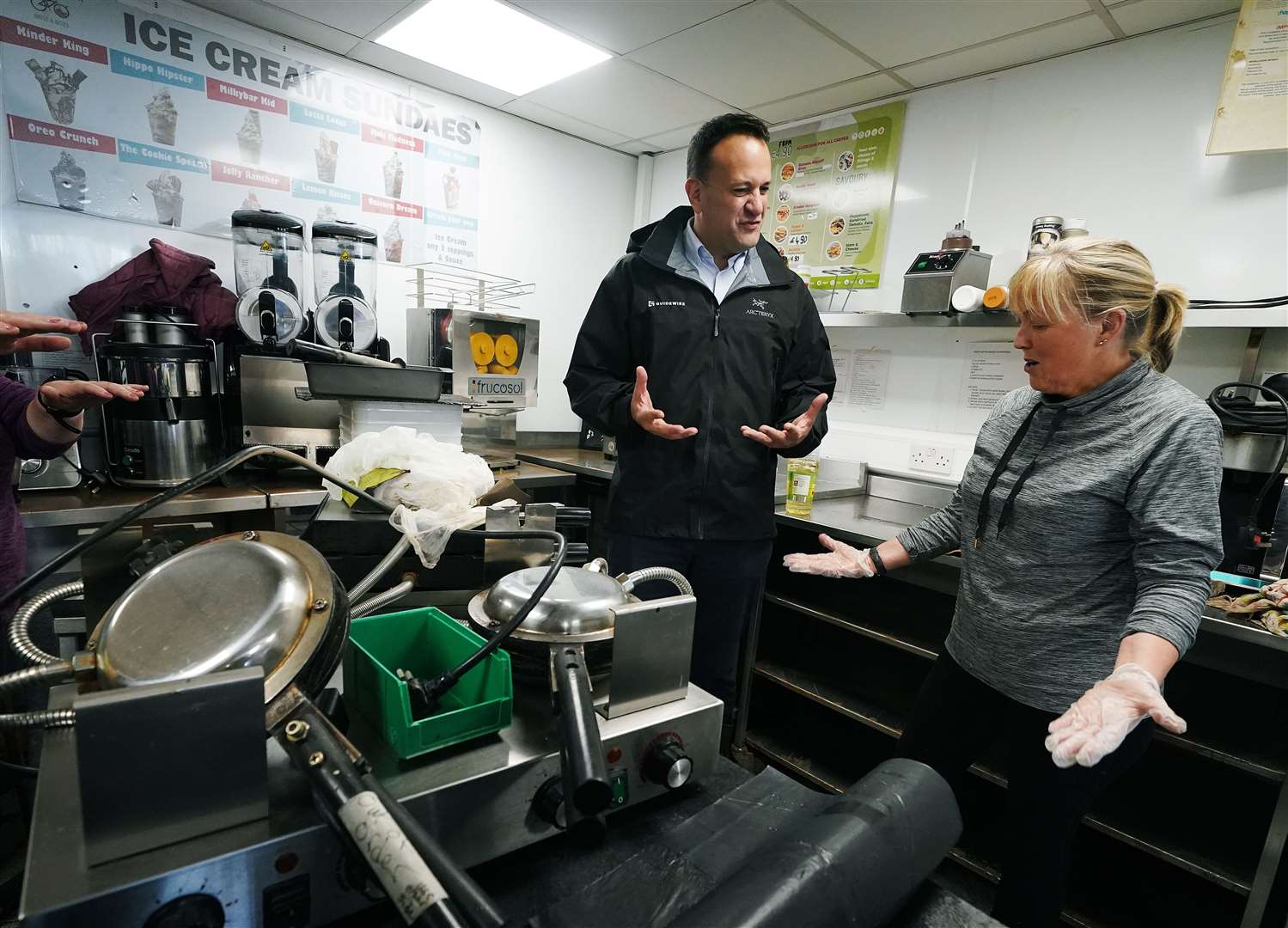 Taoiseach Leo Varadkar speaks with Frances Steele as she helps clean up a business belonging to a friend on Main Street in Midleton (PA)