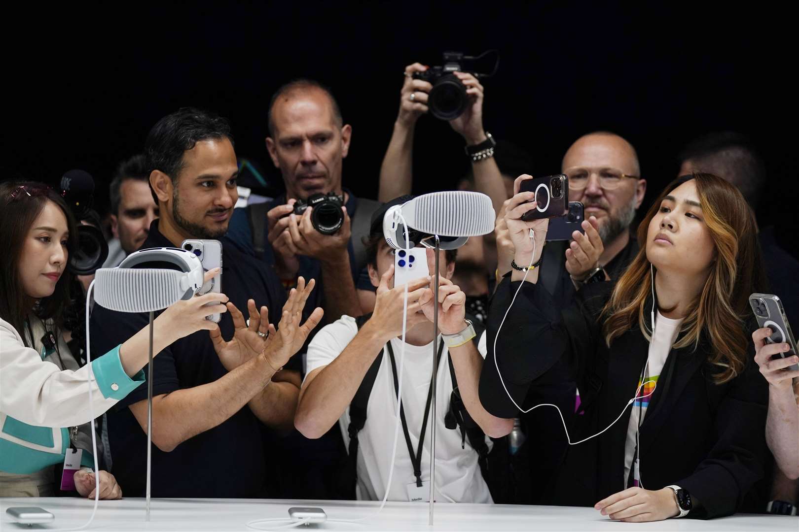 A crowd gathers around the Apple Vision Pro headset as it is displayed in a showroom on the Apple campus (AP Photo/Jeff Chiu)