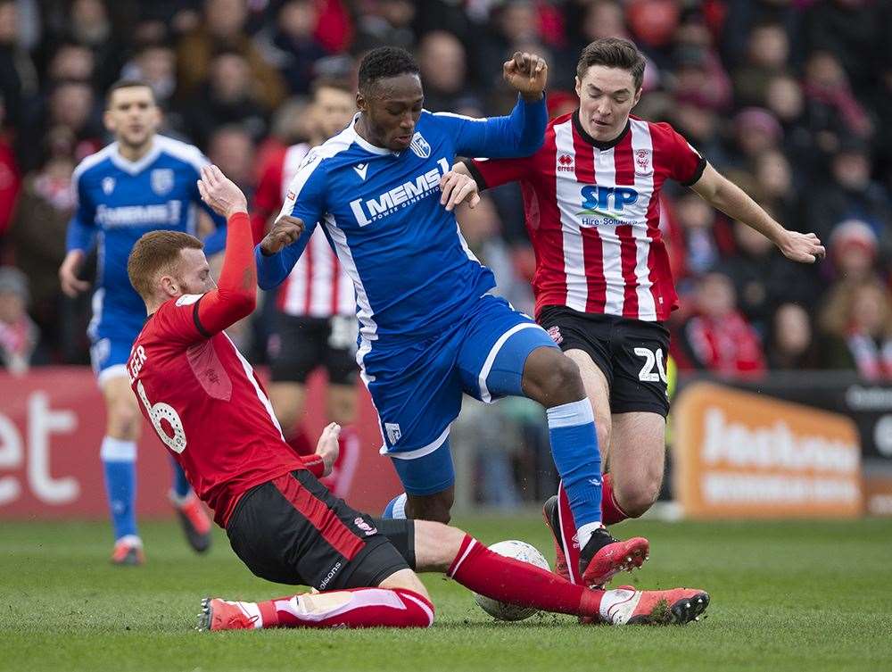 It takes two Lincoln defenders to halt Gillingham on Saturday. Picture: Ady Kerry