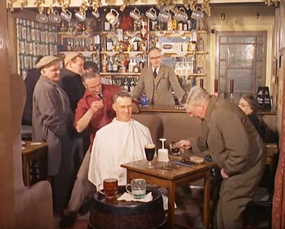 A punter sips a pint of Guinness while having his hair cut by barber Ted Tole at The Chapter Arms in Chartham Hatch in 1964. Landlord Norman Askey is behind the bar