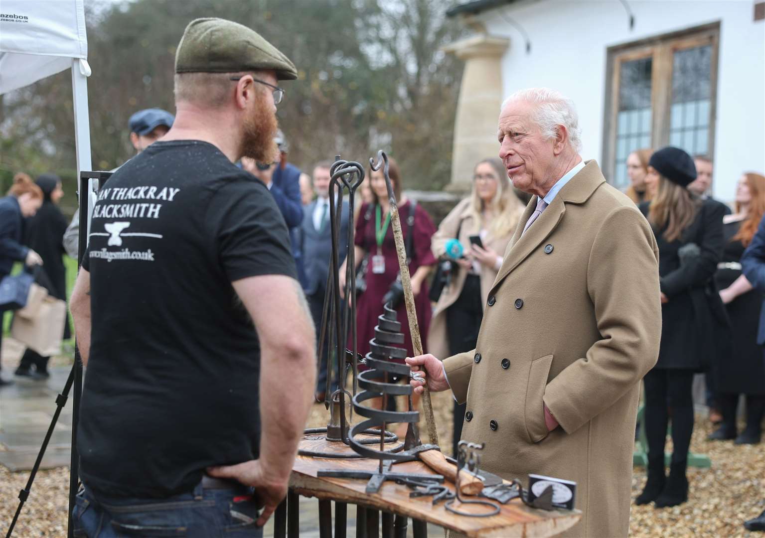 Charles talks with a blacksmith while admiring his work (Chris Jackson/PA)