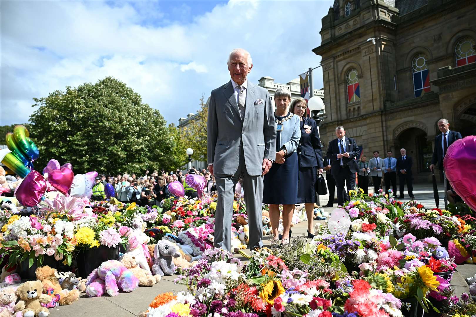 Charles views flowers left in tribute to the Southport stabbing victims during his visit to the town (Paul Ellis/PA)