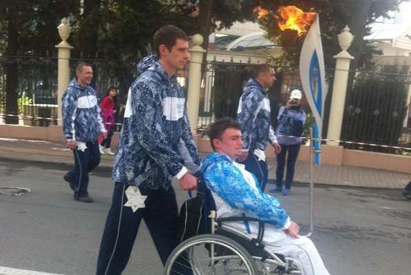 Andrew Norman carries the torch during the Paralympic Games in Sochi