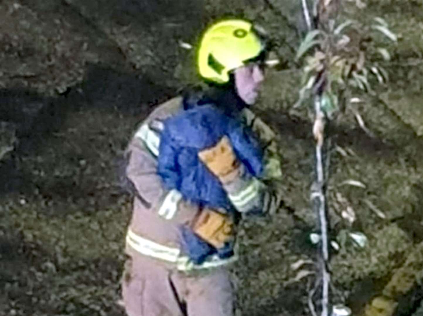 A firefighter carrying a baby to safety after the blast (Twitter user @UB1UB2/PA)