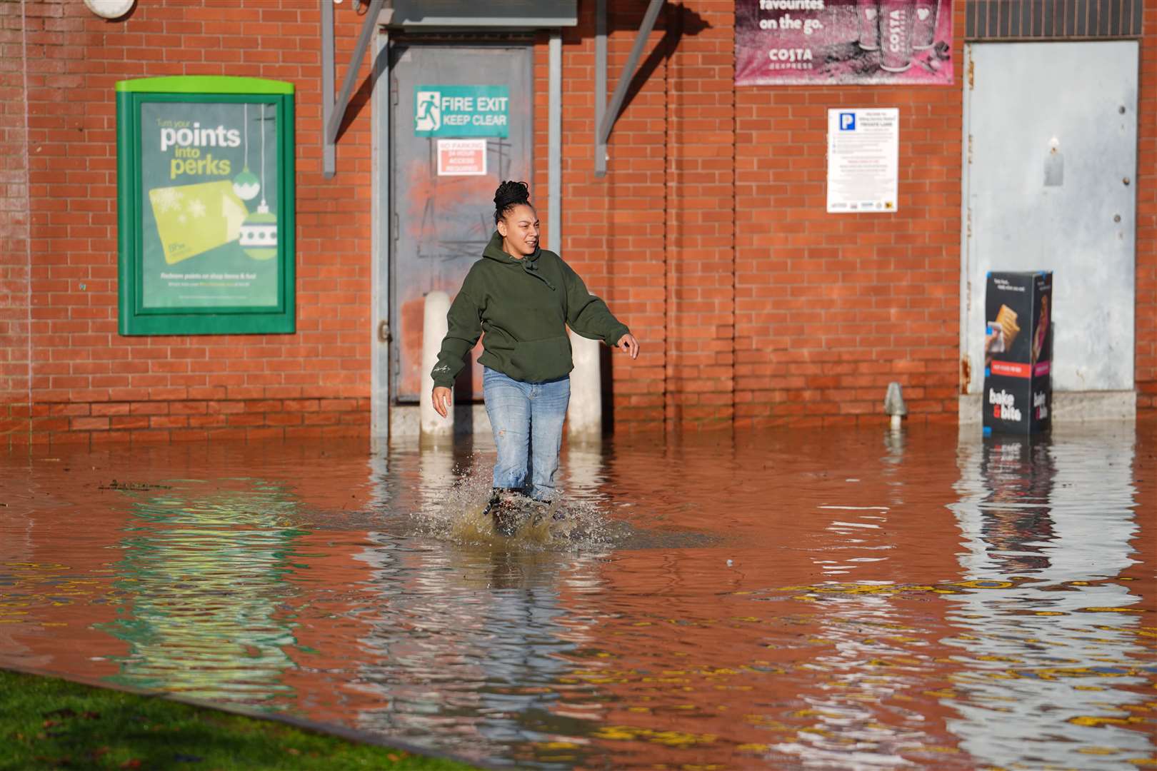 A woman at the aquadrome wades through knee-deep water (Jordan Pettitt/PA)