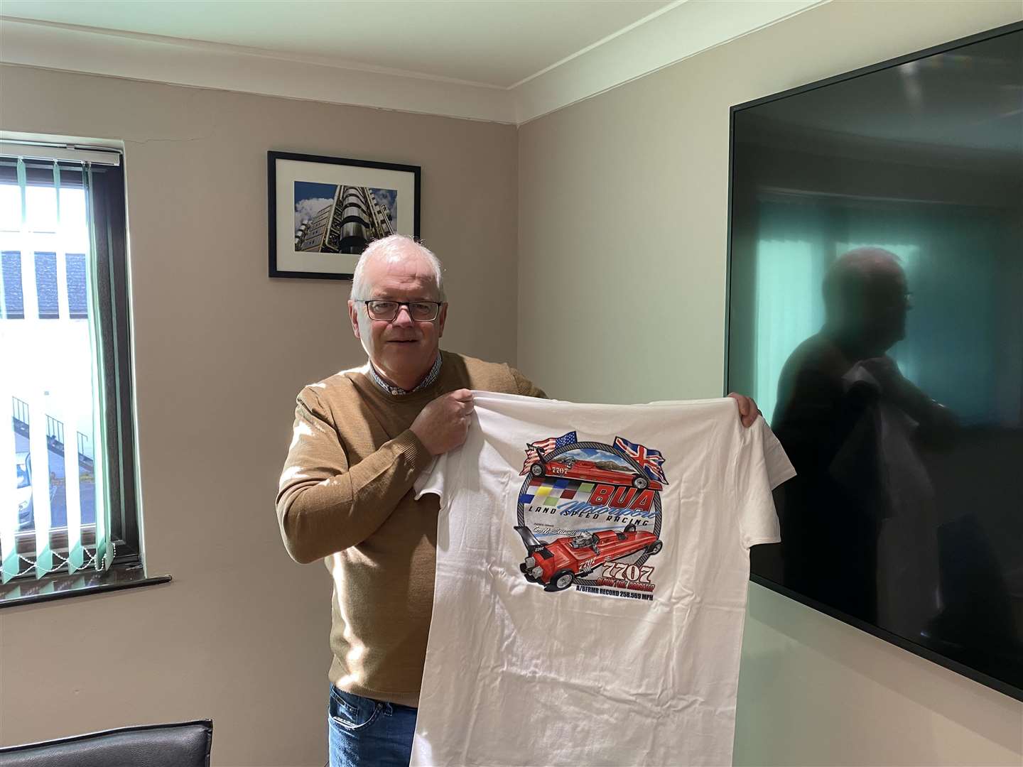 Geoff Stilwell, holding up his merch for his car (59799801)