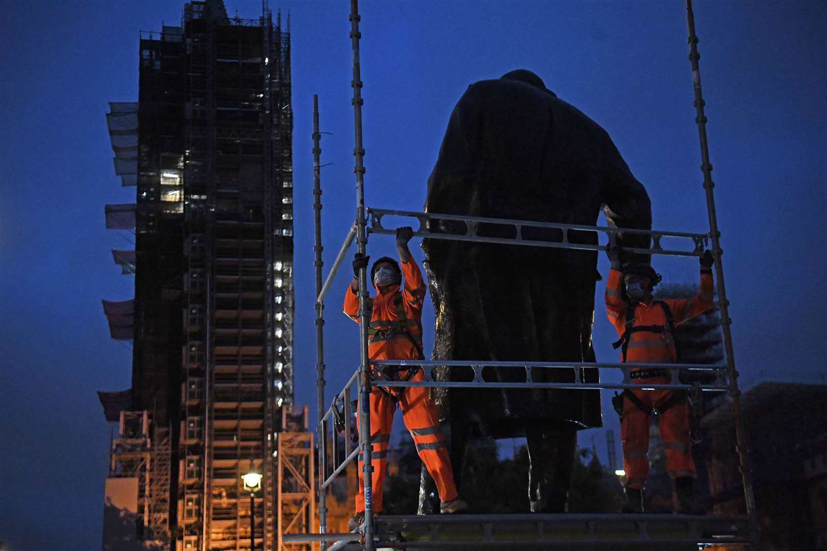 Scaffolders erect boarding around the statue of Sir Winston Churhill at Parliament Square (Kirsty O’Connor/PA)