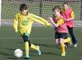 Boys and girls in football action