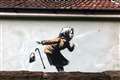 Banksy-style artwork of sneezing woman appears on wall