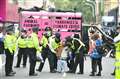 Climate activists glue themselves to the ground and block road around Parliament