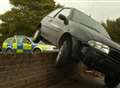 Crash car ends up perched on top of wall