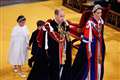 Prince Louis and Princess Charlotte hold hands during abbey arrival