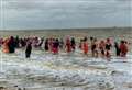 Swimmers in fancy dress take to sea for postponed New Year’s dip