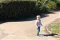 Boy waves at empty street as members of the public isolate due to coronavirus