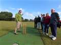 Club on sticky wicket with flying cricket balls 