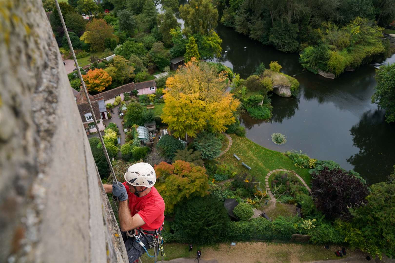 A specialist restorer works high up on Caesar’s Tower (Jacob King/PA)