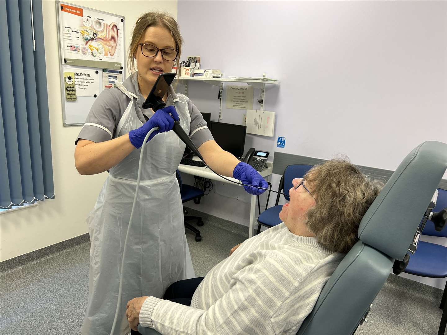 Nina Glazzard, an advanced clinical practitioner for ears, nose and throat, using the endoscope-i adapter on patient Janet Hennessy, as part of a trial at North Midlands University Hospitals NHS Trust (NHS England/PA)