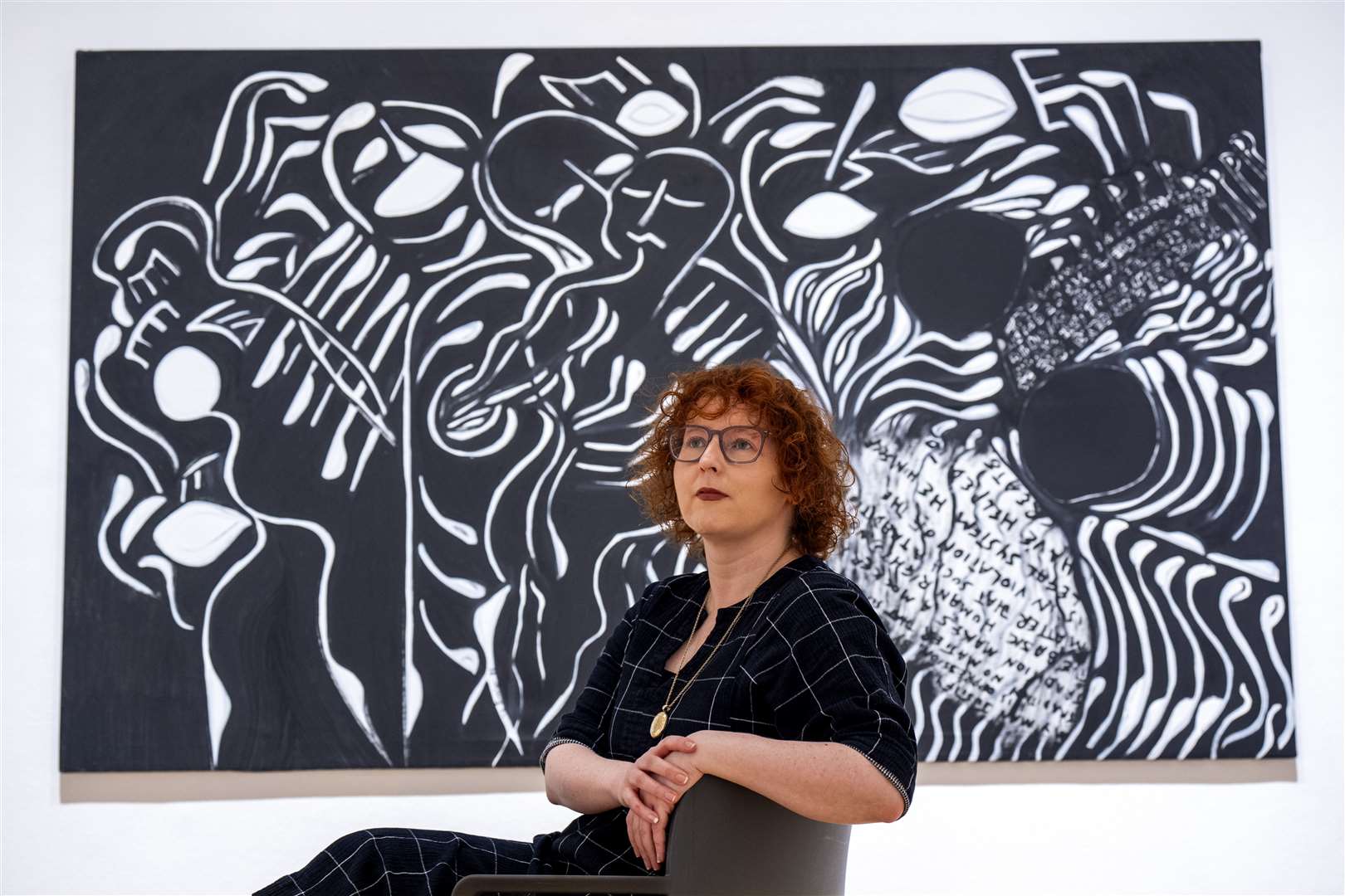 Senior curator Stephanie Straine alongside a 1985 acrylic painting titled Set Free (Jane Barlow/PA)