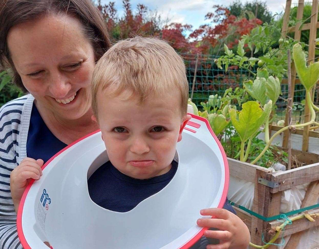 Two-year-old Noah with mum Carla and the toilet seat stuck around his neck