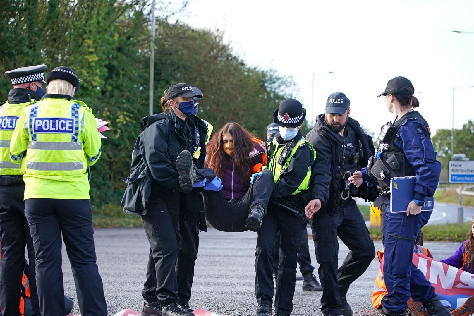 Protesters from Insulate Britain are removed by police after they blocked a road near to the Holiday Inn Express Motorway Airport in Manchester (Peter Byrne/PA)