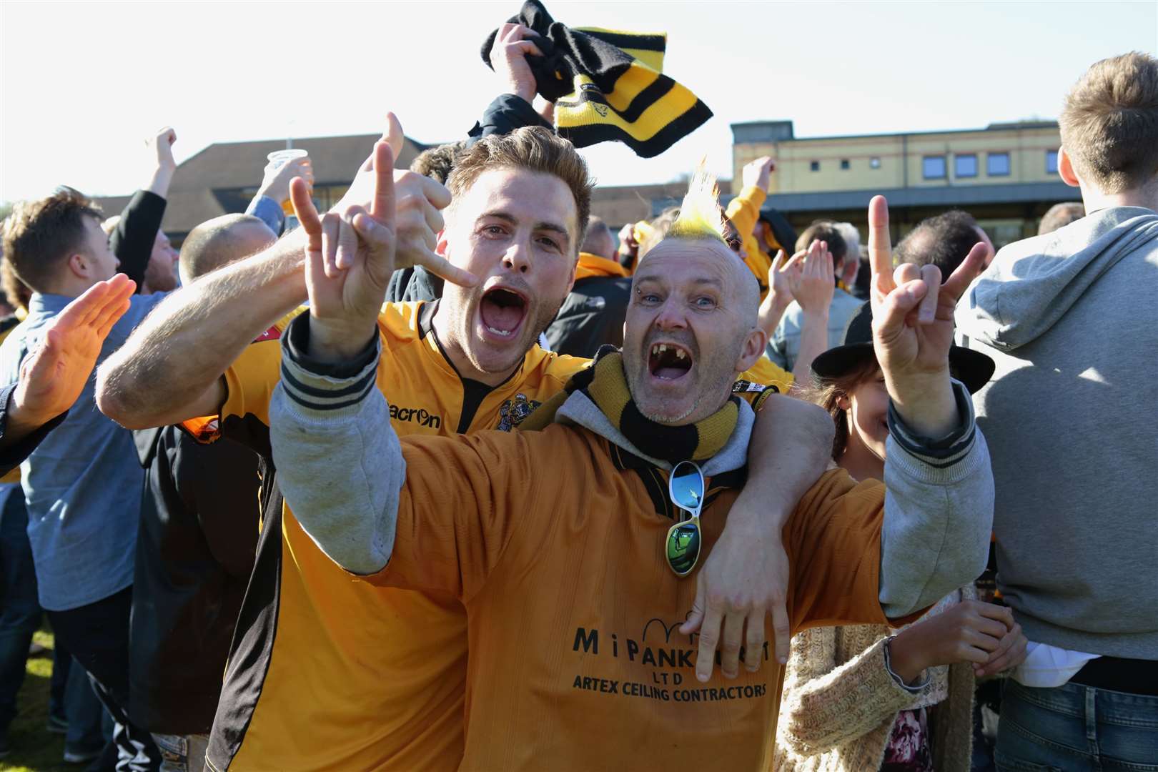 Fans on the pitch celebrate as a goalless draw at Champion Hill which all-but confirmed the title