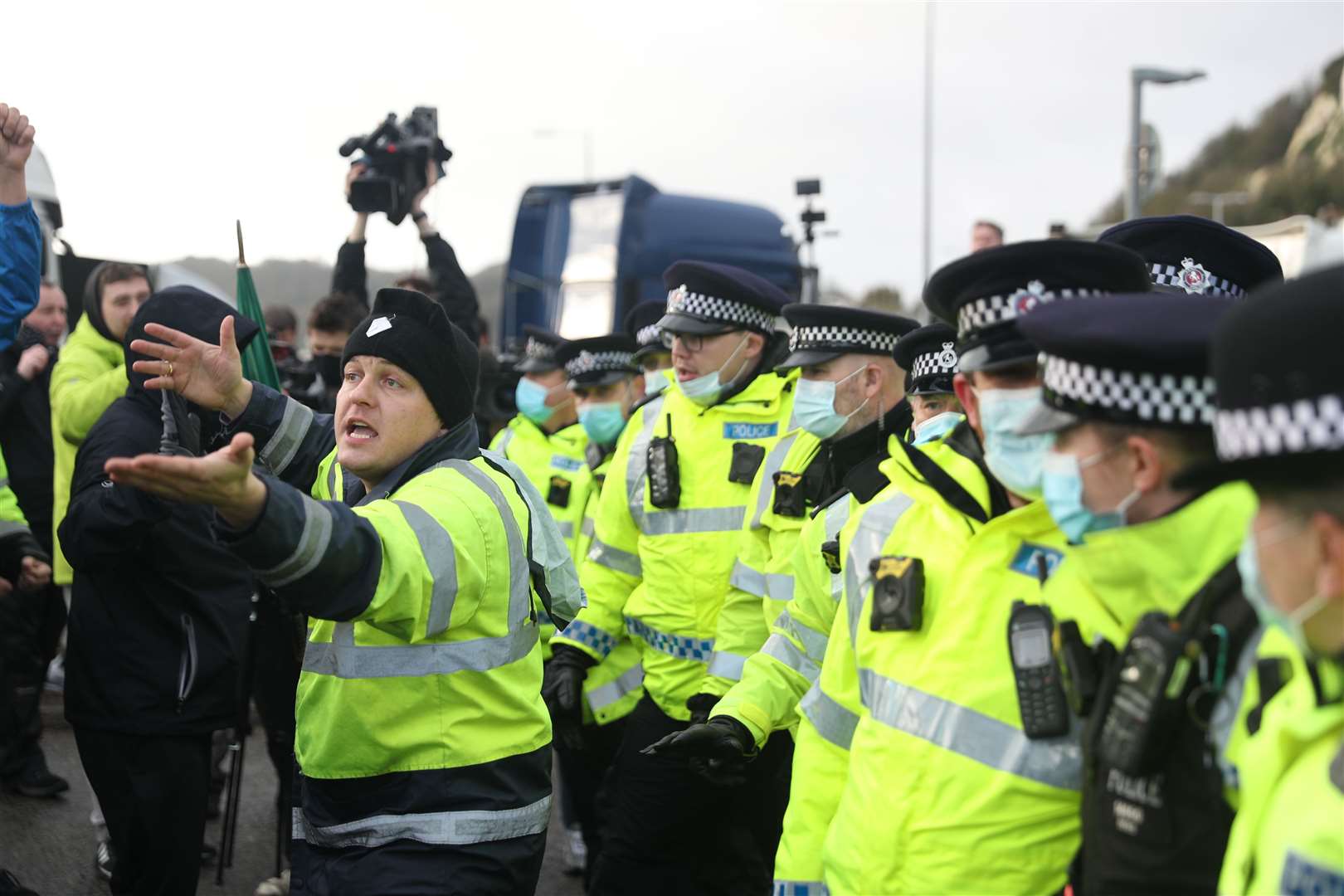 Lorry drivers hold up their arms as they tussle with police at the entrance to the Port of Dover in Kent (Andrew Matthews/PA)