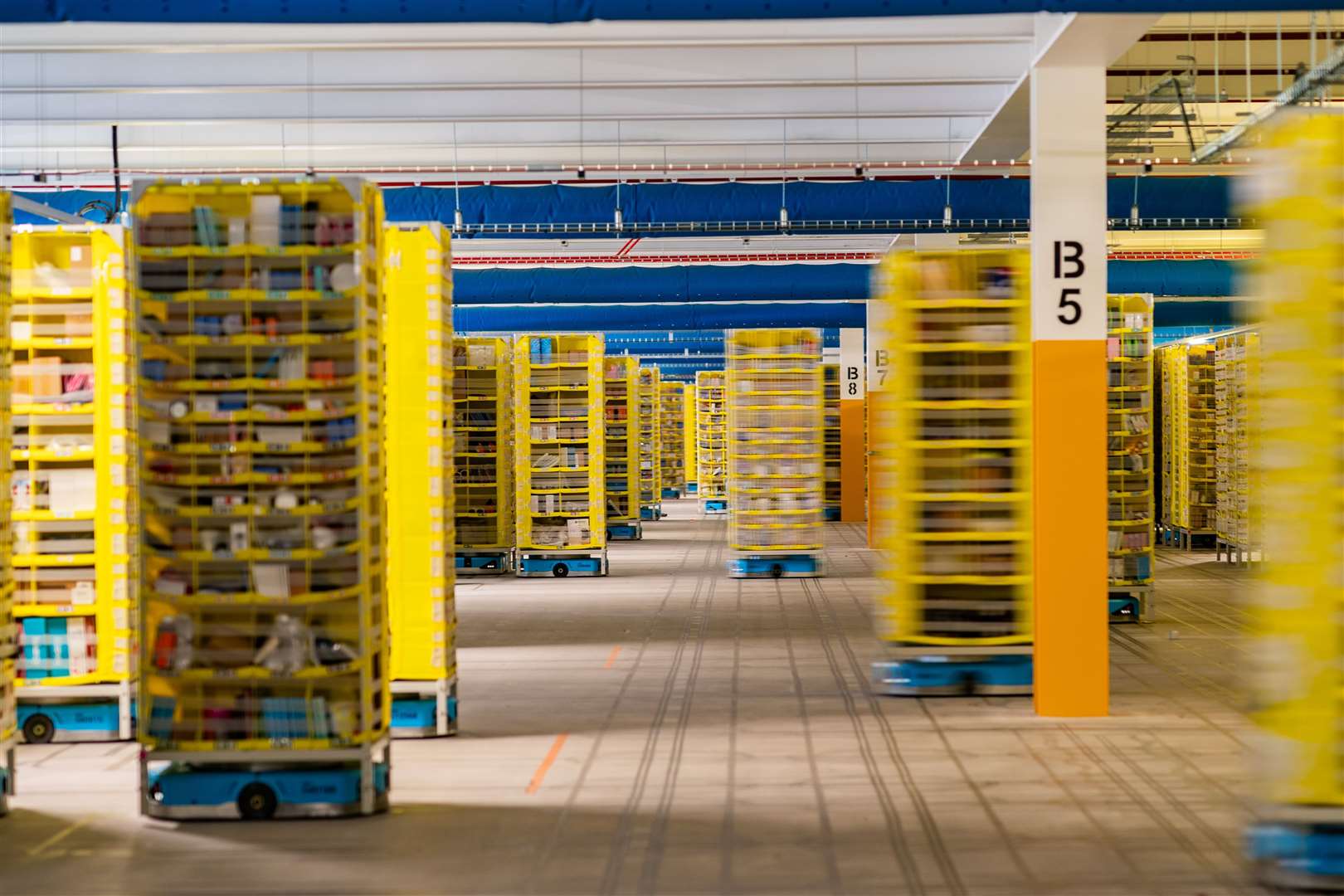 Yellow shelves move around on blue automated robots (Ben Birchall/PA)