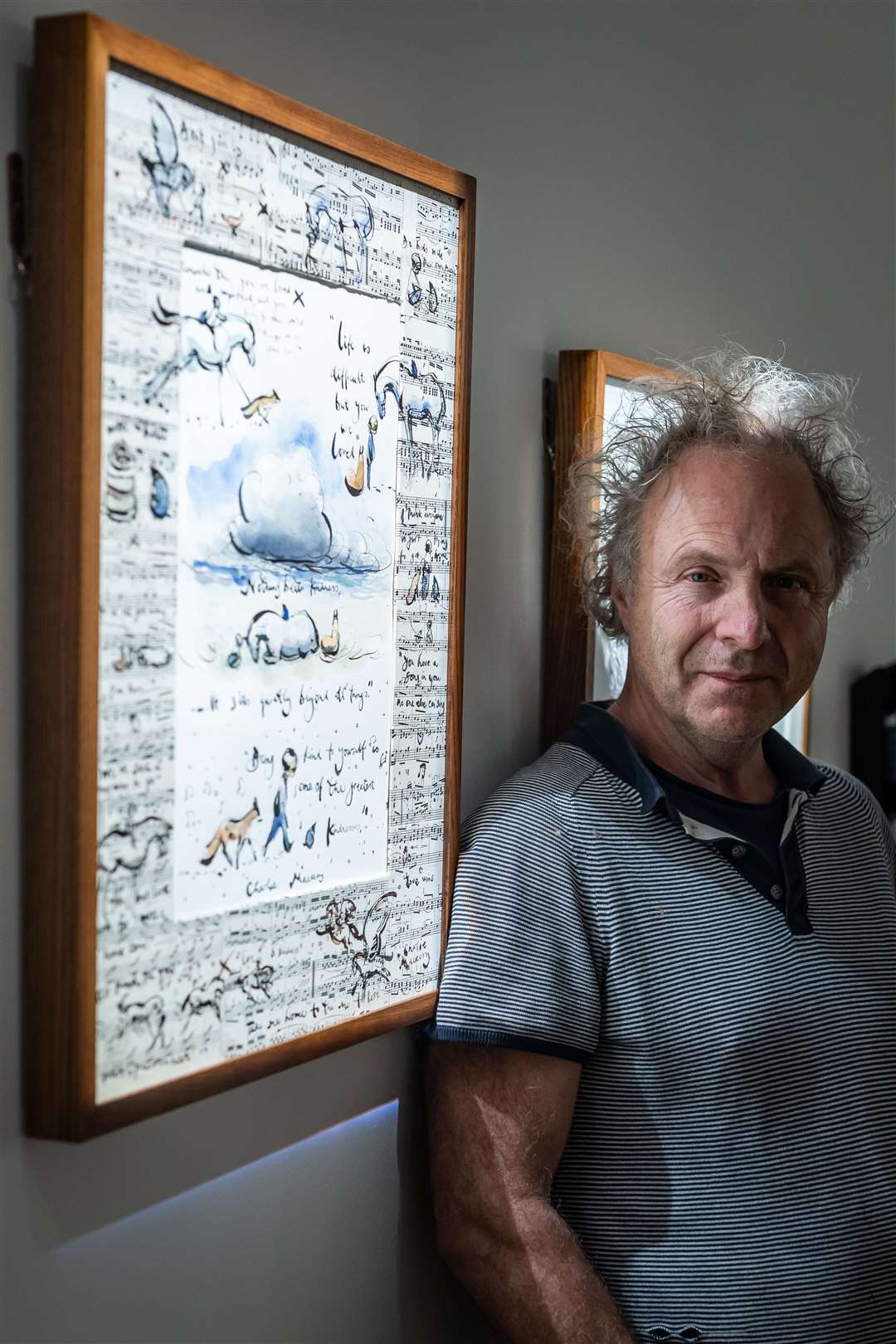 Author and illustrator Charlie Mackesy next to ‘You are Loved’ a part of his exhibition ‘Look How Far We’ve Come’ at Sotheby’s in London (Aaron Chown/PA)