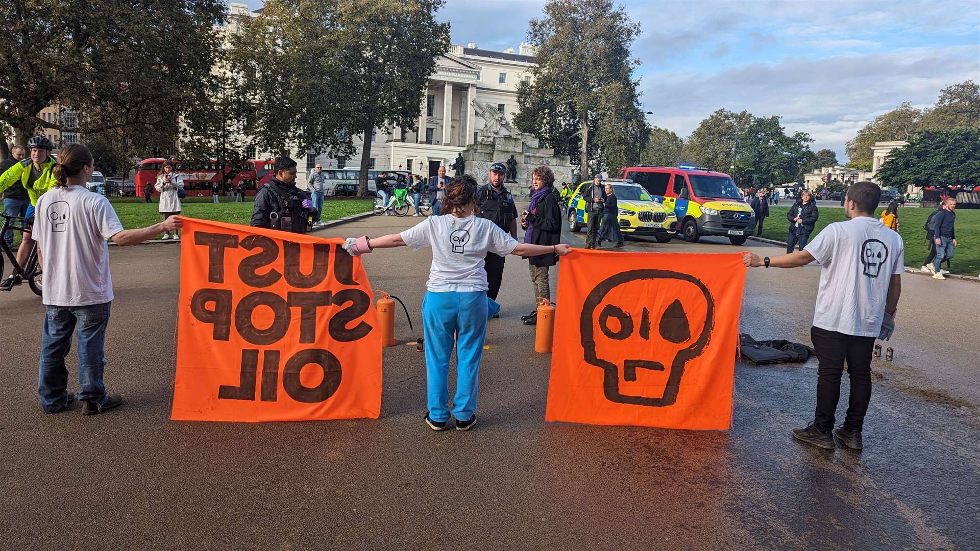 One of the protesters holding two orange JSO banners (Just Stop Oil/PA)